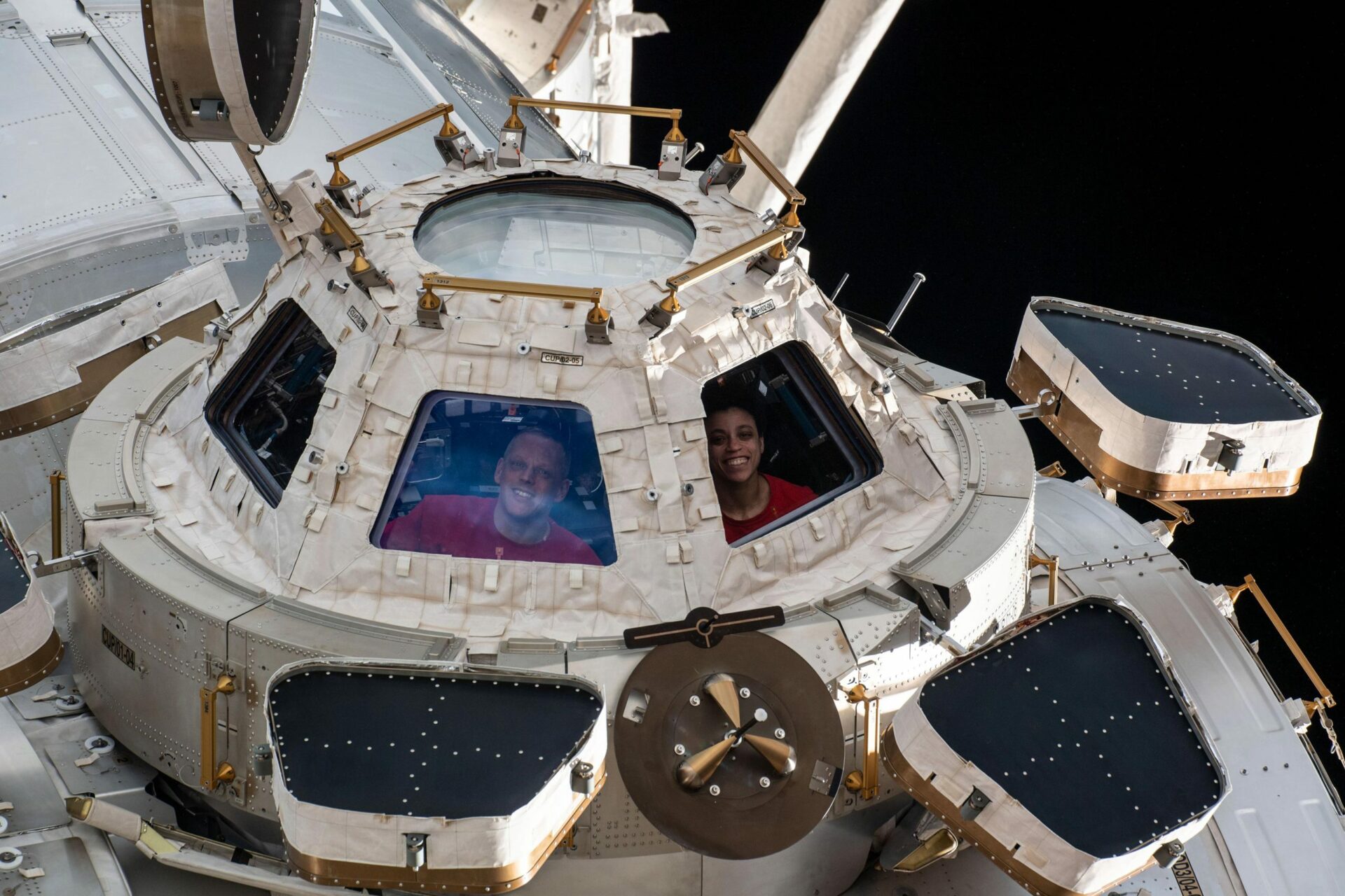 Бортинженеры NASA Боб Хайнс и Джессика Уоткинс, изображенные, глядя в окно на модуле Cupola
