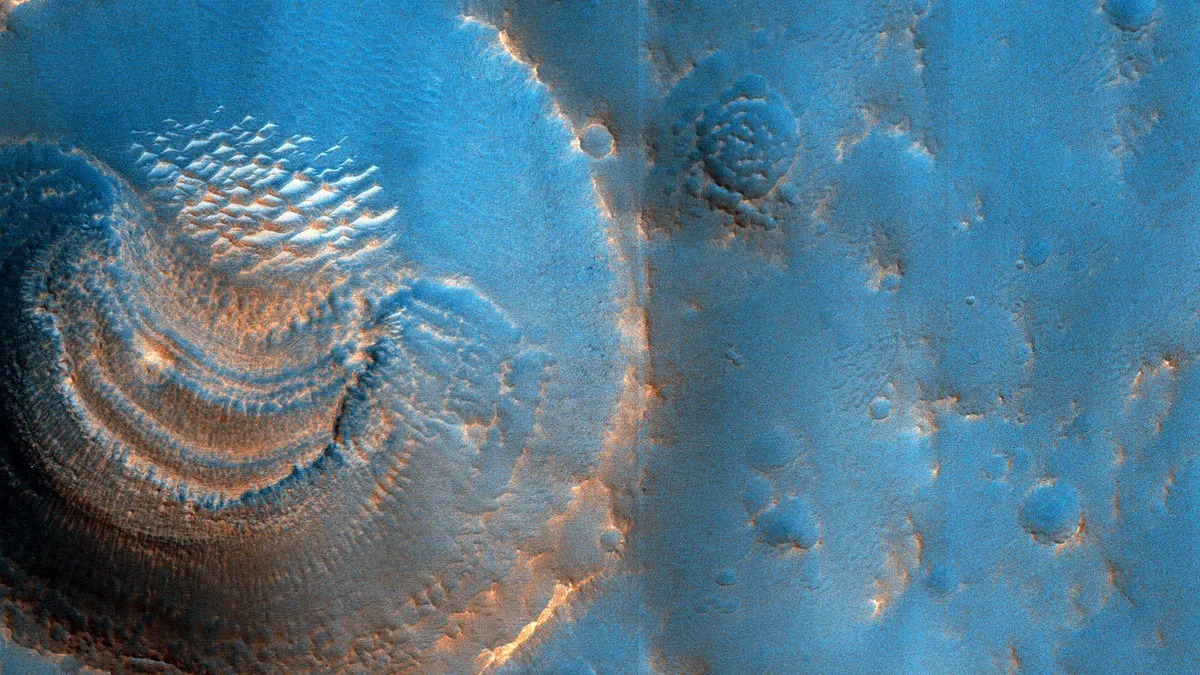 Scientists are puzzled by mysterious “smiles” inside a crater on Mars