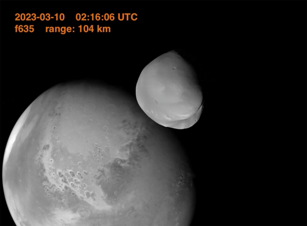 Деймос на фоне Марса