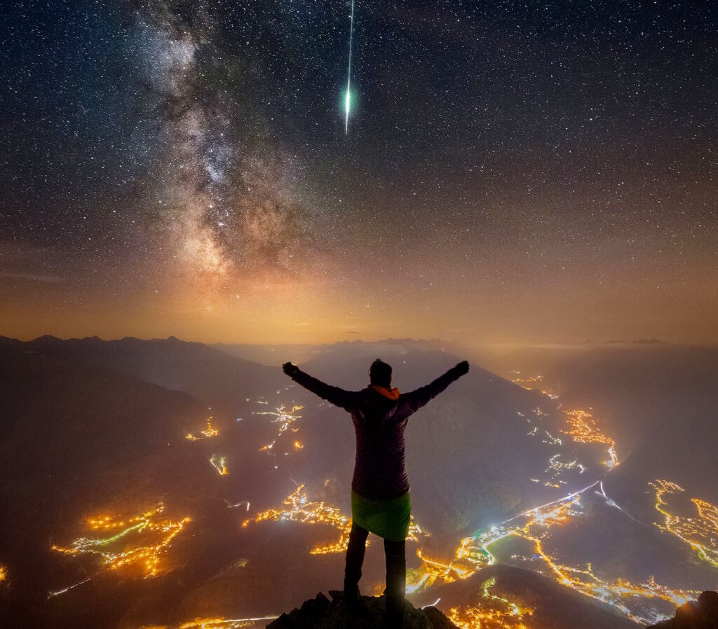 Фотограф снимает падающую звезду и галактику Млечный Путь, находясь на вершине альпийской горы Чиргант