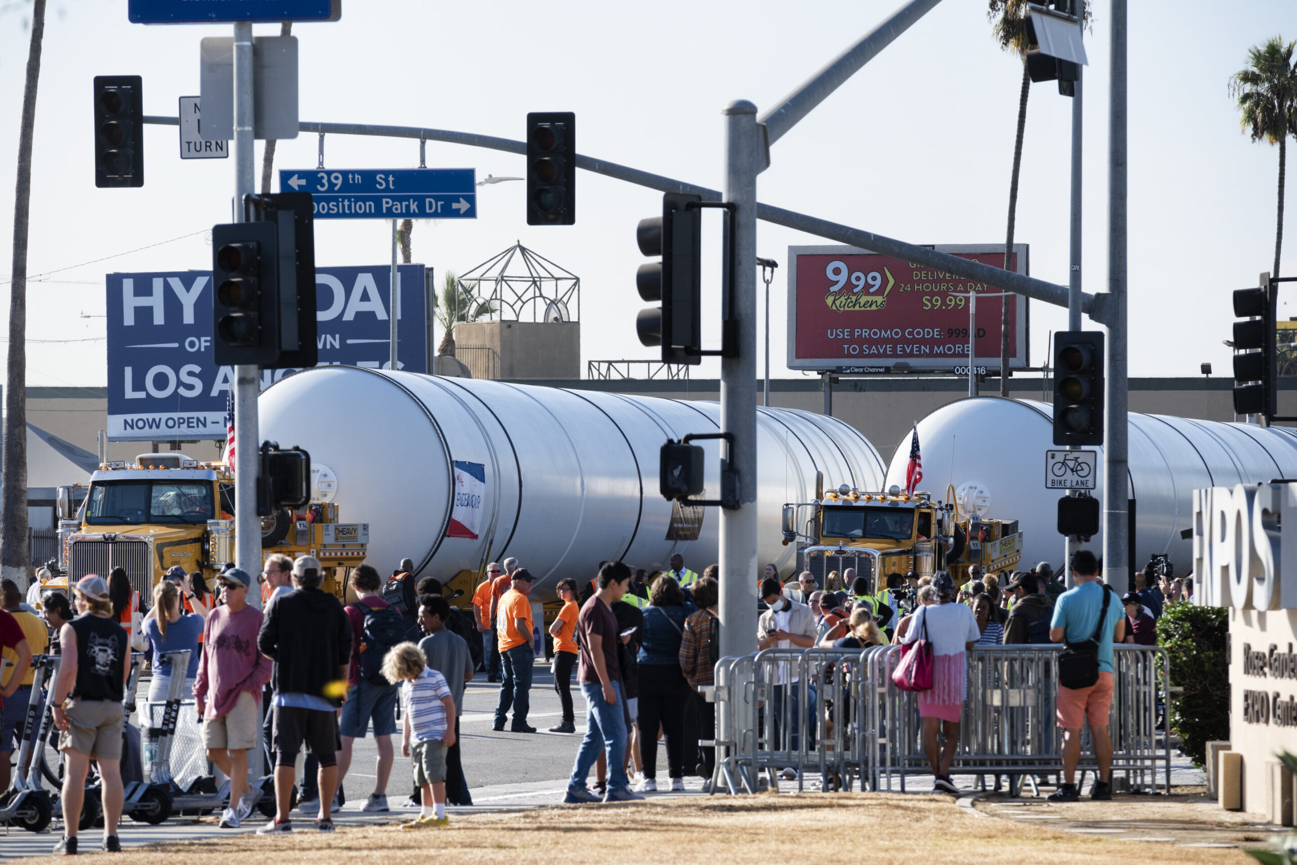 Зрители наблюдают, как два ракетных двигателя медленно движутся по улице Фигероа в Лос-Анджелесе 11 октября 2023 года