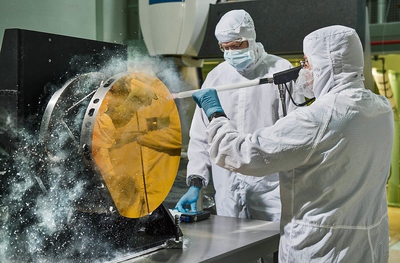 Инженеры очищают одно из зеркал "снегом" из охлажденного углекислого газа