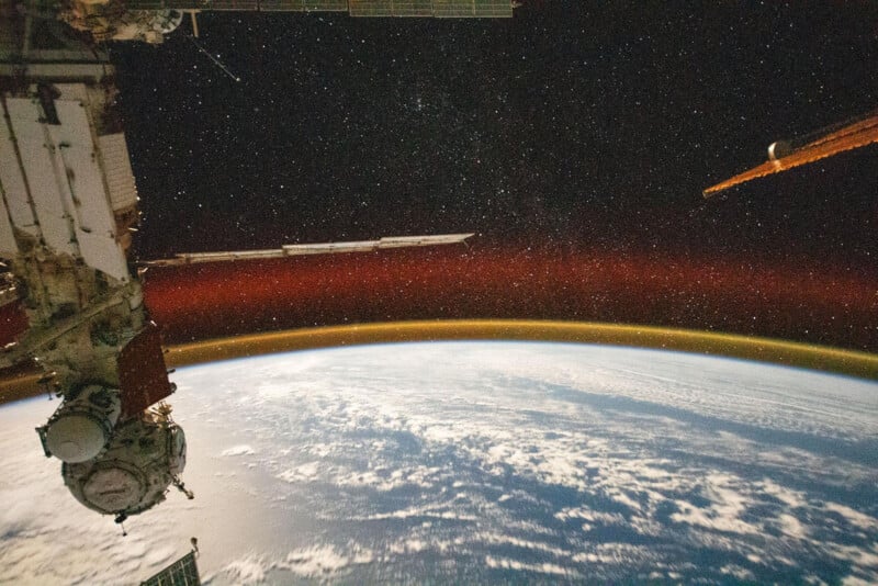 Эта фотография сделана с Международной космической станции, показывает сияние атмосферы Земли и звездное небо на высоте 400 км над Тихим океаном к северо-востоку от Папуа-Новой Гвинеи