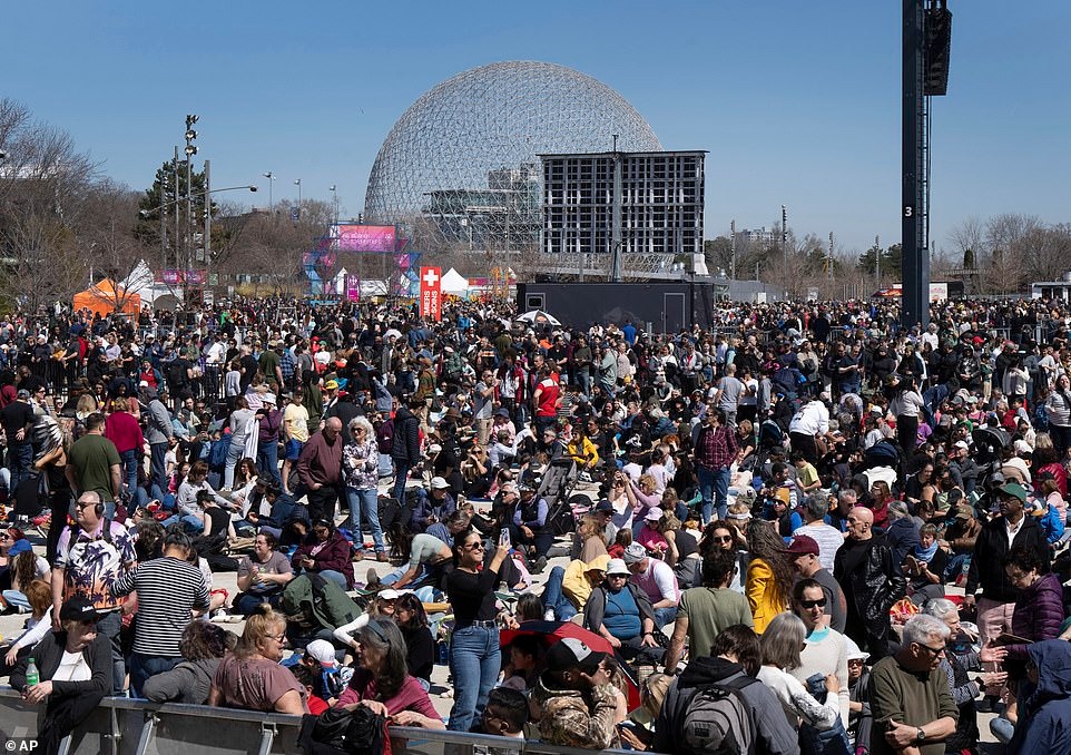Люди собираются, чтобы посмотреть на полное солнечное затмение в Монреале, Канада