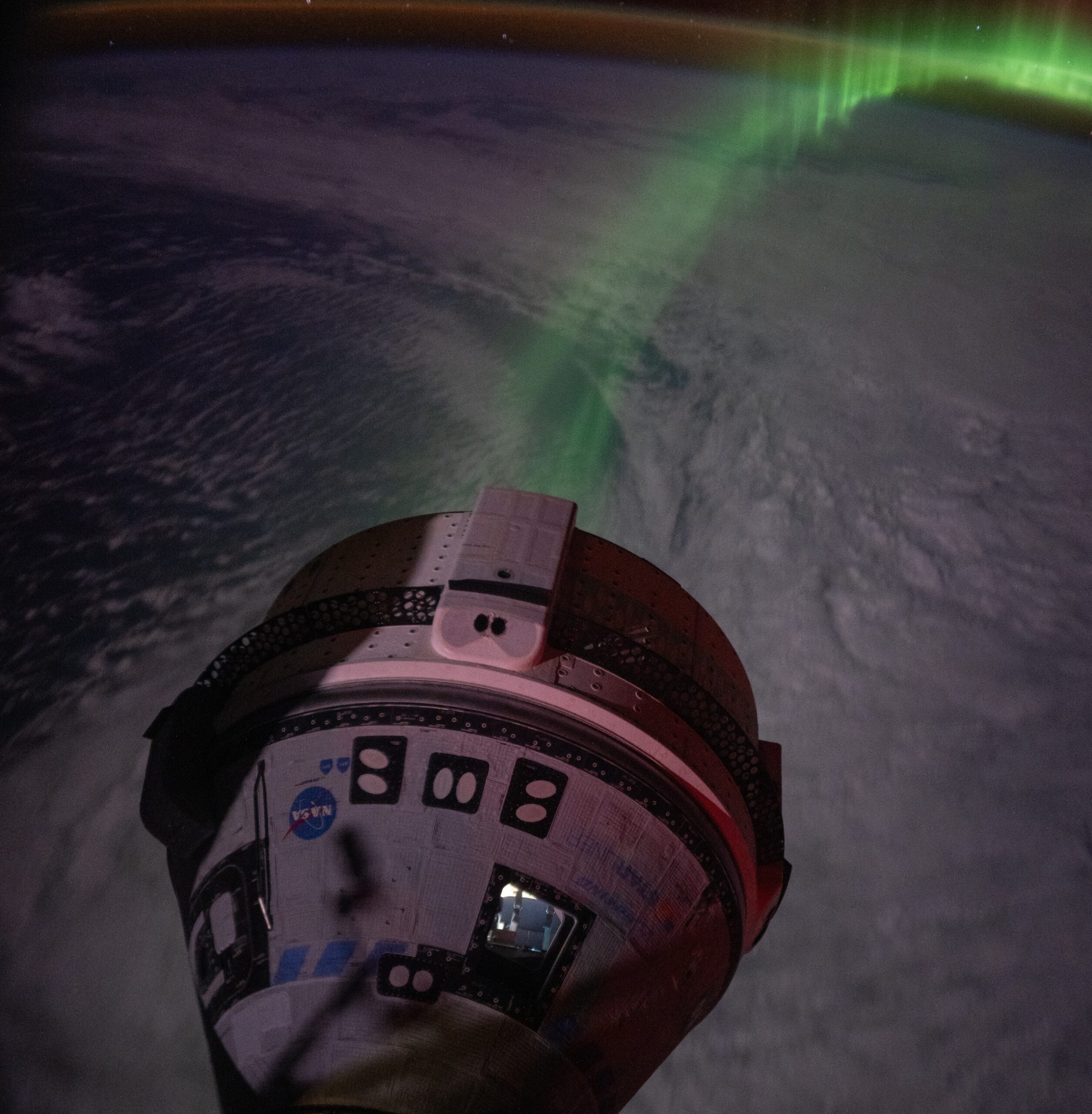 Astronauts watch a touching Starliner flight against the background of the aurora