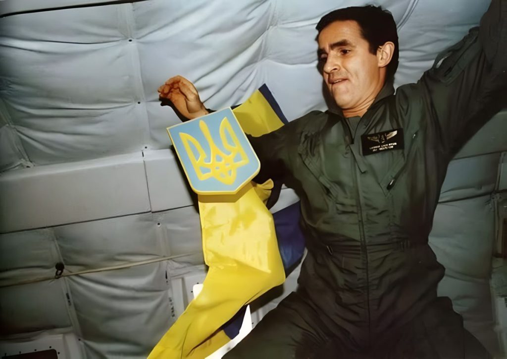 Леонід Каденюк тримає герб України поряд з прапором у невагомості на борту шатла Columbia