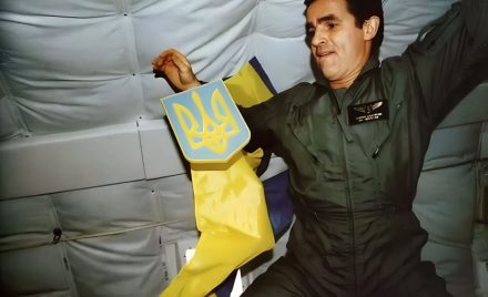 Леонід Каденюк тримає герб України поряд з прапором у невагомості на борту шатла Columbia