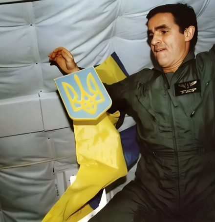 Леонід Каденюк тримає герб України поряд з прапором у невагомості на борту шатла Columbia
