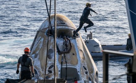 Рятувальні команди працюють біля капсули SpaceX Dragon Freedom, що гойдається на хвилях Тихого океану після приводнення.