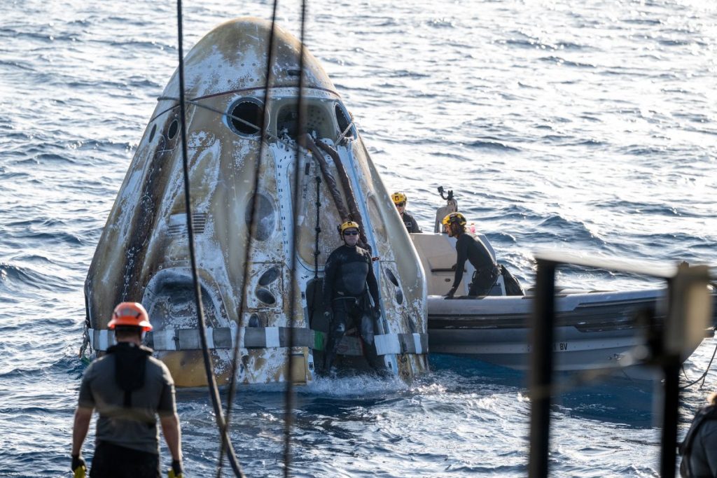 Співробітники пошуково-рятувальної групи на човнах біля капсули SpaceX Dragon Freedom на поверхні Тихого океану.
